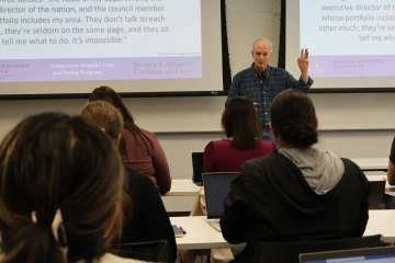 Stephen Cornell raises a hand to invite participation during a JIT lecture.